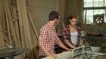 Two young carpenters doing woodwork at furniture manufacturing video