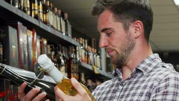 jovem homem olhando confuso enquanto escolhendo vinho video