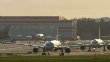 MOSCOW, RUSSIAN FEDERATION SEPTEMBER 12, 2020 - Airplanes taxiing in backlight, airfield video