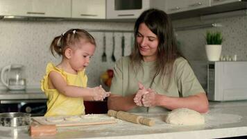 alegre madre y hija para 2 años preparando pasteles desde masa y harina a masa.casa cocinar, niño educación, hogar comida dulce pasteles video