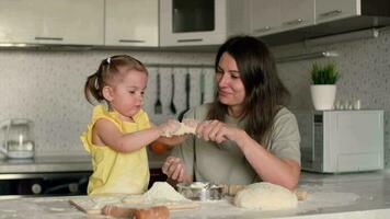 allegro madre e figlia siamo Ingannare in giro mentre cucinando pasticcini a partire dal impasto.impasto cucinando, bambino istruzione, casa cibo, dolce pasticcini. video