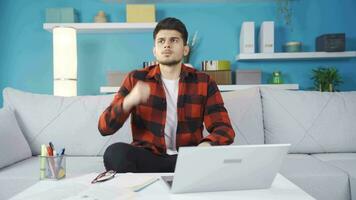 viendo su fracaso en el computadora portátil, el joven hombre es frustrado y enojado. video