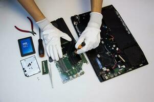 Top view. Technician repairing notebook computer, repairing motherboard and circuit. photo