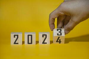 The concept of the end of 2023 and the new beginning of 2024 changes from 2023 to 2024 in wooden block form. photo
