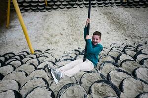 Young boy having fun on a swing at the playground. photo