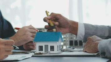 Hauskäufer treffen sich und verhandeln mit Immobilienmaklern über die Anmietung oder den Kauf eines Hauses im Büro. video