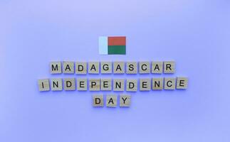 diciembre 30, república día de Madagascar, minimalista bandera con el inscripción en de madera letras en un azul antecedentes foto