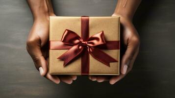 AI generative. Female hands holding a gift box with a red ribbon on a wooden background. photo