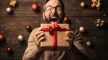 AI generative. Man in glasses holding a gift box on a wooden background with Christmas decorations. photo