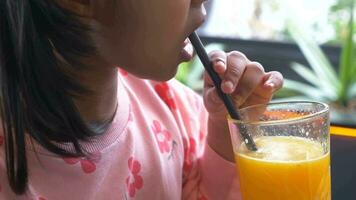 child hand holding a glass of orange juice video