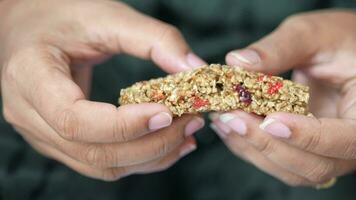 women hand breaking oat protein bar video