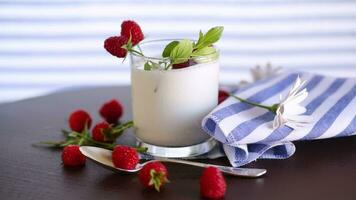 Sweet cooked homemade yogurt with fresh raspberries in a glass. video