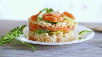 fervido branco arroz com salgado vermelho peixe, pepinos e de outros legumes . video