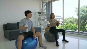 Young Asian Couple Taking a Break And Drinking Water After Working Out at Home video