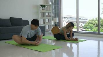 jovem casal fazendo ioga às casa juntos video
