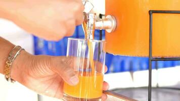 mujer mano prensas naranja jugo dentro un vaso. video