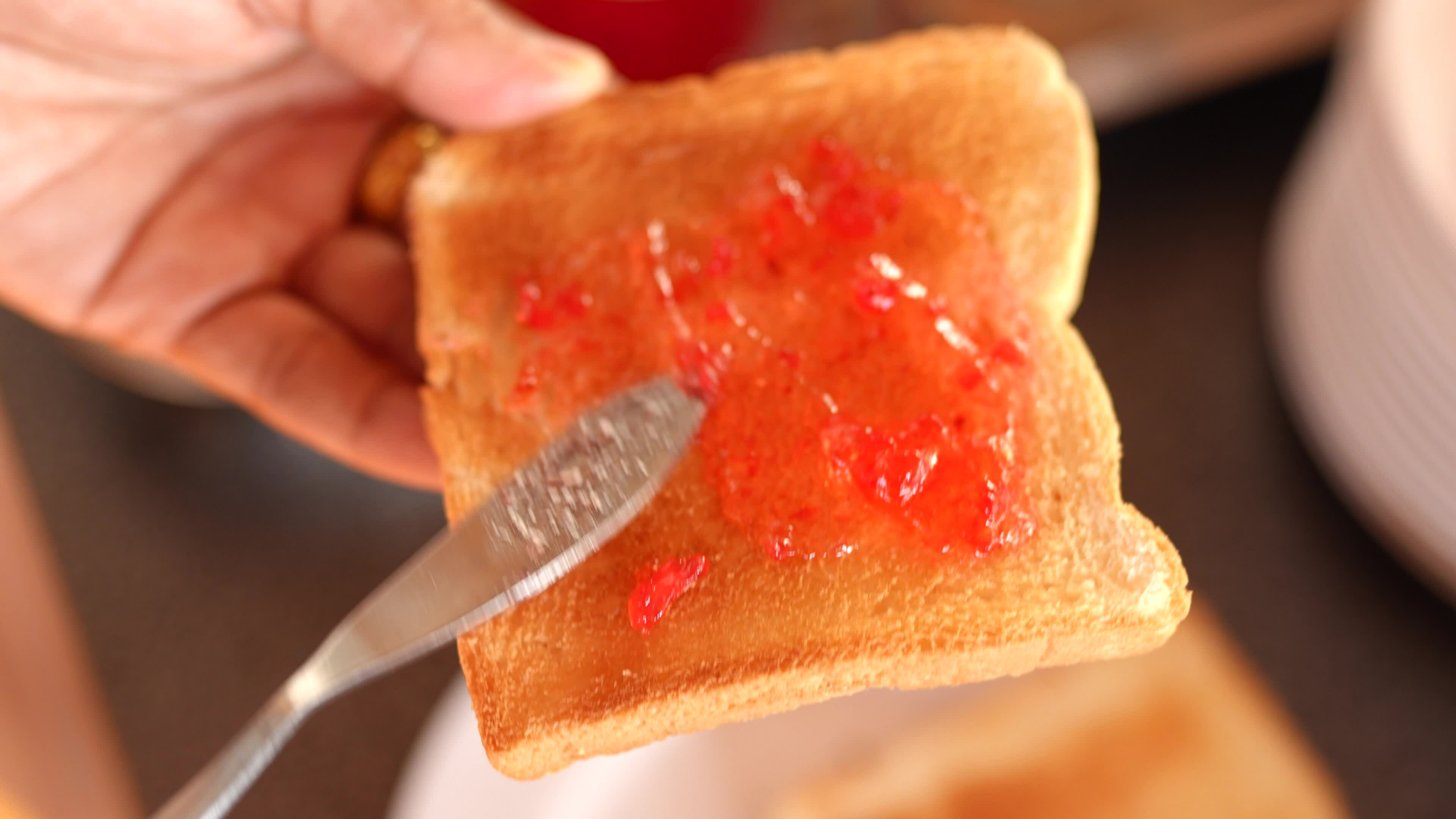 Woman's hand spreading jam on toast 33139028 Stock Video at Vecteezy