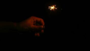 Happy New Year 2024. Human hands light fireworks to celebrate the New Year festival, countdown night rain. video