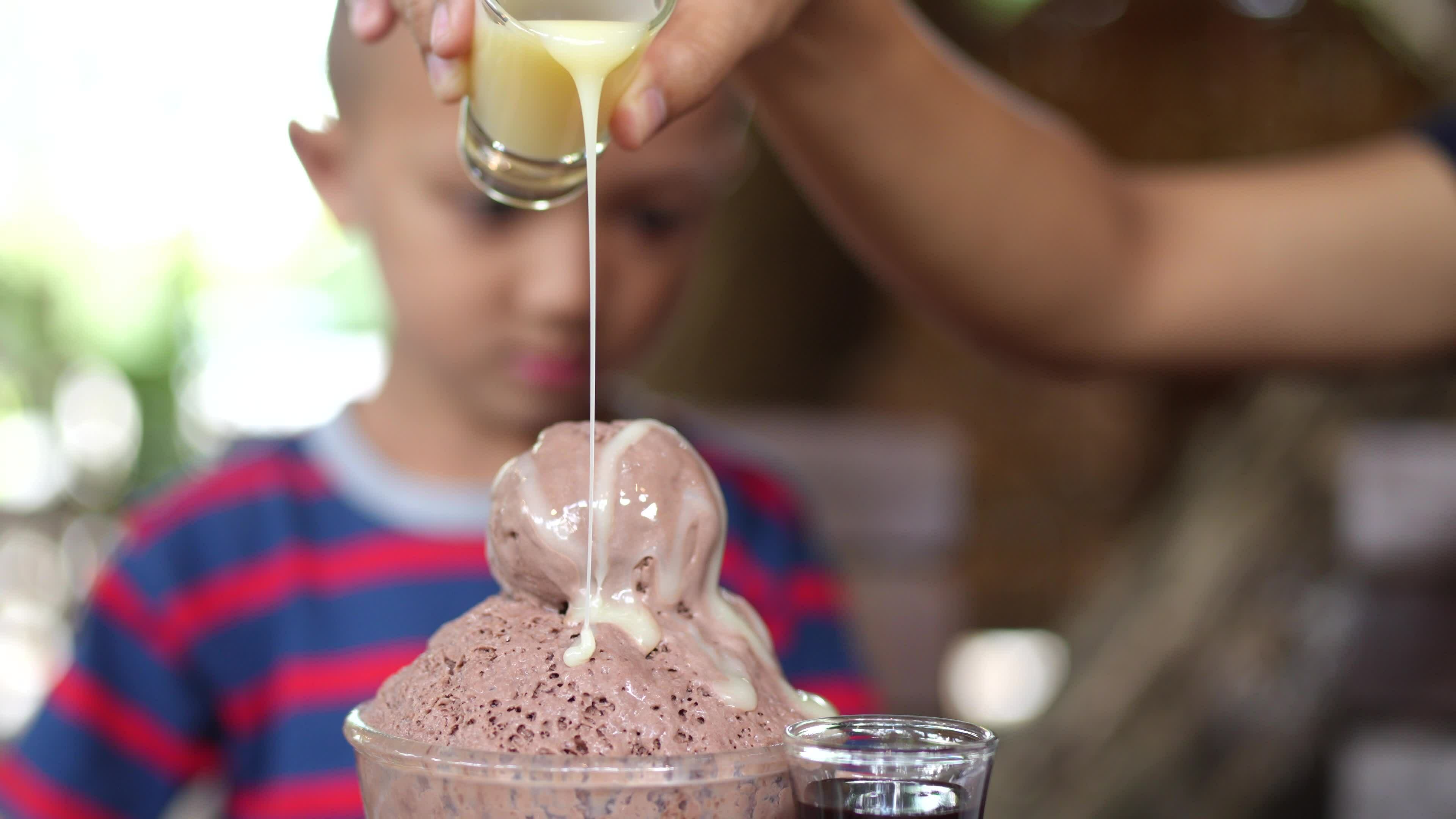 Mother pours milk on ice cream 33139185 Stock Video at Vecteezy