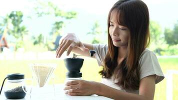 een vrouw giet koffie Boon poeder in een houder en stammen de water. video