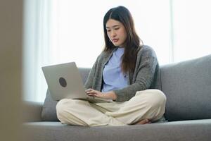Happy beautiful Asian Woman. Business woman working from home with laptop Financial Home work space concept. photo