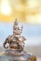 Deity of God Indra is riding Erawan Airavata three head elephant, the Bronze Statue on yellow and pastel shade background. photo