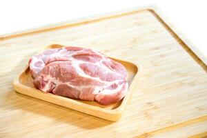 Raw Pork is prepared for Cook, It is on wood plate in studio light with Chef hand background. Clipping Paths. photo