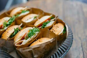 A group of homemade HAMBURGER is wrapped with paper craft and arranged on the dish, ready to serve and eat. photo