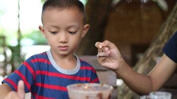 Mom gives ice cream to son to eat. video