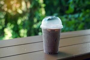 Glass of iced chocolate, iced cocoa on a wooden table in a coffee shop It is a cold drink made from concentrated cocoa powder. It has a delicious and refreshing taste. It is a popular menu item. photo