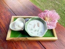 caramelized crisps in coconut sauce, a popular Thai dessert with coconut milk It looks like boiled flour served in coconut milk. Sprinkled with fragrant roasted sesame seeds. photo