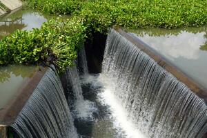 Waterfall from check Concrete dams, which are constructions that block the flow of water, can slow down the flow of water and keep sediment from flowing down and depositing in the river below. photo