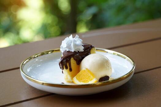 Cocoa Cotton Cake is a cake with a strong cream cheese flavor. The texture is soft and light, similar to chiffon. Gently top the cake with cocoa, serve with ice cream and decorate with orange petals. photo