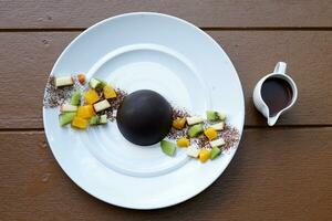 Chocolate dome by covering cookies. Fruit and ice cream of your choice. How to eat, Put warm chocolate on the dome until it melts and you're ready to enjoy the rich ice cream and chocolate lattice. photo
