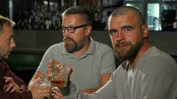 Handsome man looking to the camera with confidence while drinking whiskey video