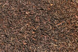 Background of tea, Dry black tea leaves closeup as background, Top view closeup photo