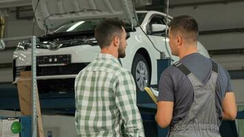 Rear view shot of a mechanic and customer shaking hands at the garage video