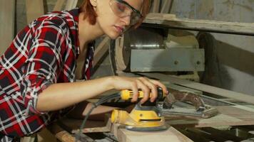 Diligent female carpenter sanding wood at the workshop video