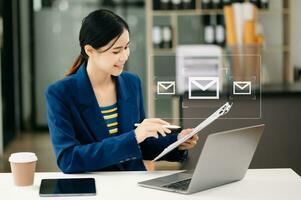 Woman hands using Laptop, tablet typing on keyboard and surfing the internet with email icon, email marketing concept, send e-mail or newsletter, online working internet network technology. photo