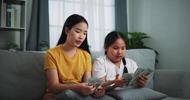 Footage of young women and teen girl counting cash money on sofa in the living room at home,Happy counting dollars banknote. video