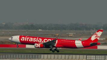 BANGKOK, THAILAND MARCH 01, 2023 - Airbus A330, HSXTC of AirAsia X landing and touching, braking at Suvarnabhumi Airport, side view. Aircraft arriving video