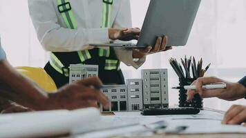 arquitectónico ingeniero equipo reunión utilizar de planos, construcción dibujos y cálculos para arquitectónico proyectos y Ingenieria herramientas en el lugar de trabajo técnico estructura concepto. video