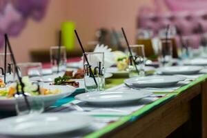 Serving table in the children's cafe. Plates and glasses on a ta photo