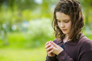 Beautiful girl among cherry flowers in spring. Portrait of a girl with brown hair and green eyes. photo