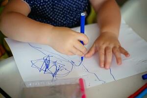 manos de un pequeño niño dibujo marcadores creatividad de bebés. temprano desarrollo foto