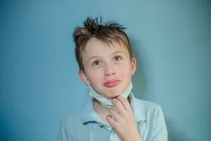 pequeño chico incursionando tomó apagado protector médico máscara desde rostro. enfermedad prevención, salud cuidado concepto foto