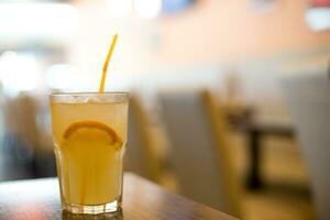 A glass of juice and a slice of Orange and straw photo