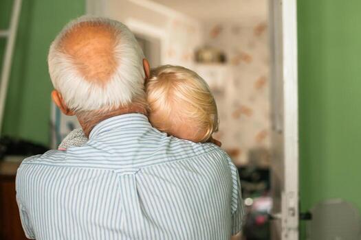 canoso abuelo con un rubio niña en brazos. del abuelo y de la nieta cabeza es cerca por. de cerca foto de gracioso dos personas antiguo abuelo pequeño nieta