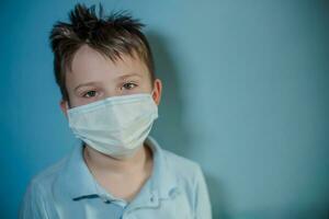 10 años antiguo chico en medicina cuidado de la salud máscara en azul antecedentes. foto