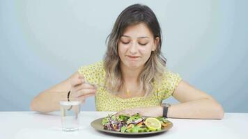 Person looking at vegetable on fork with unhappy expression. Difficulty dieting. video